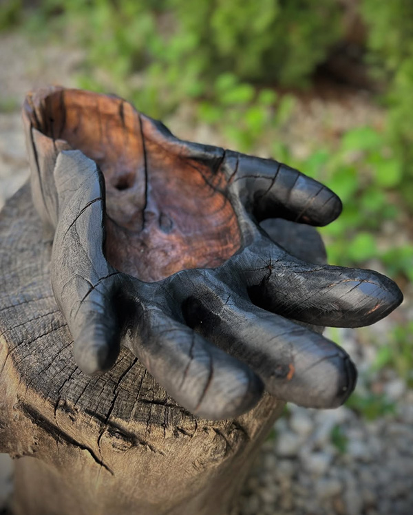 Hand-carved and fire burned reclaimed wood sculpture of a hand